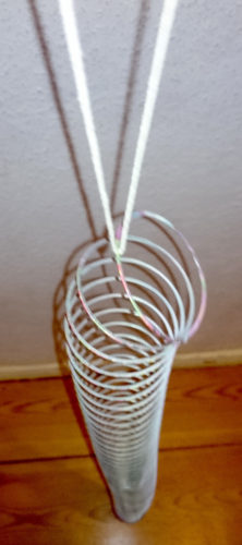 lange Spiralfeder (slinky) an einer Schnur, von oben gesehen